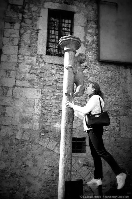 A visitor kissing the stone lioness statue in Girona