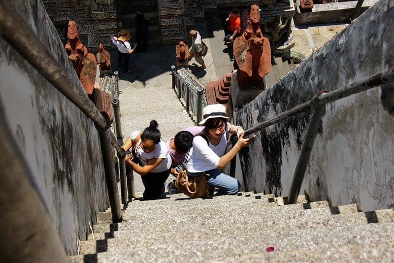 A group of ladies make their way up the impossibly steep Wat Arun - Bangkok, Thailand