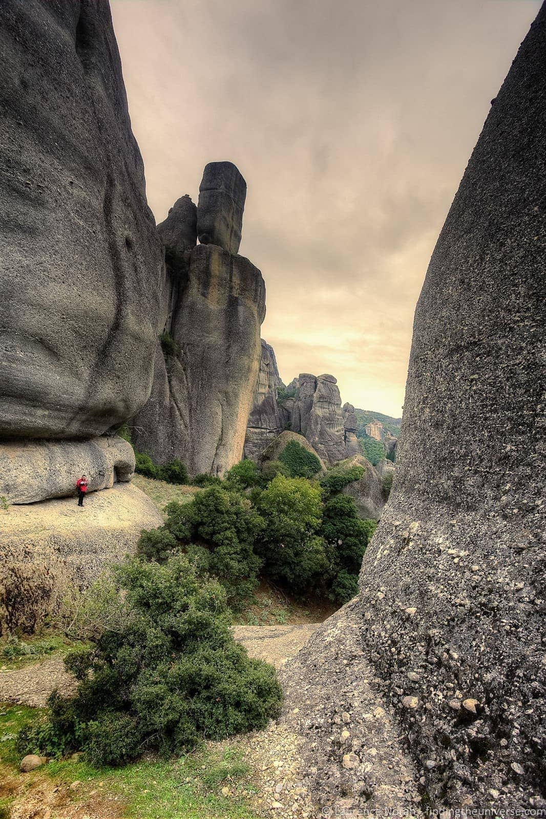 man in rock formation meteora greece - scaled