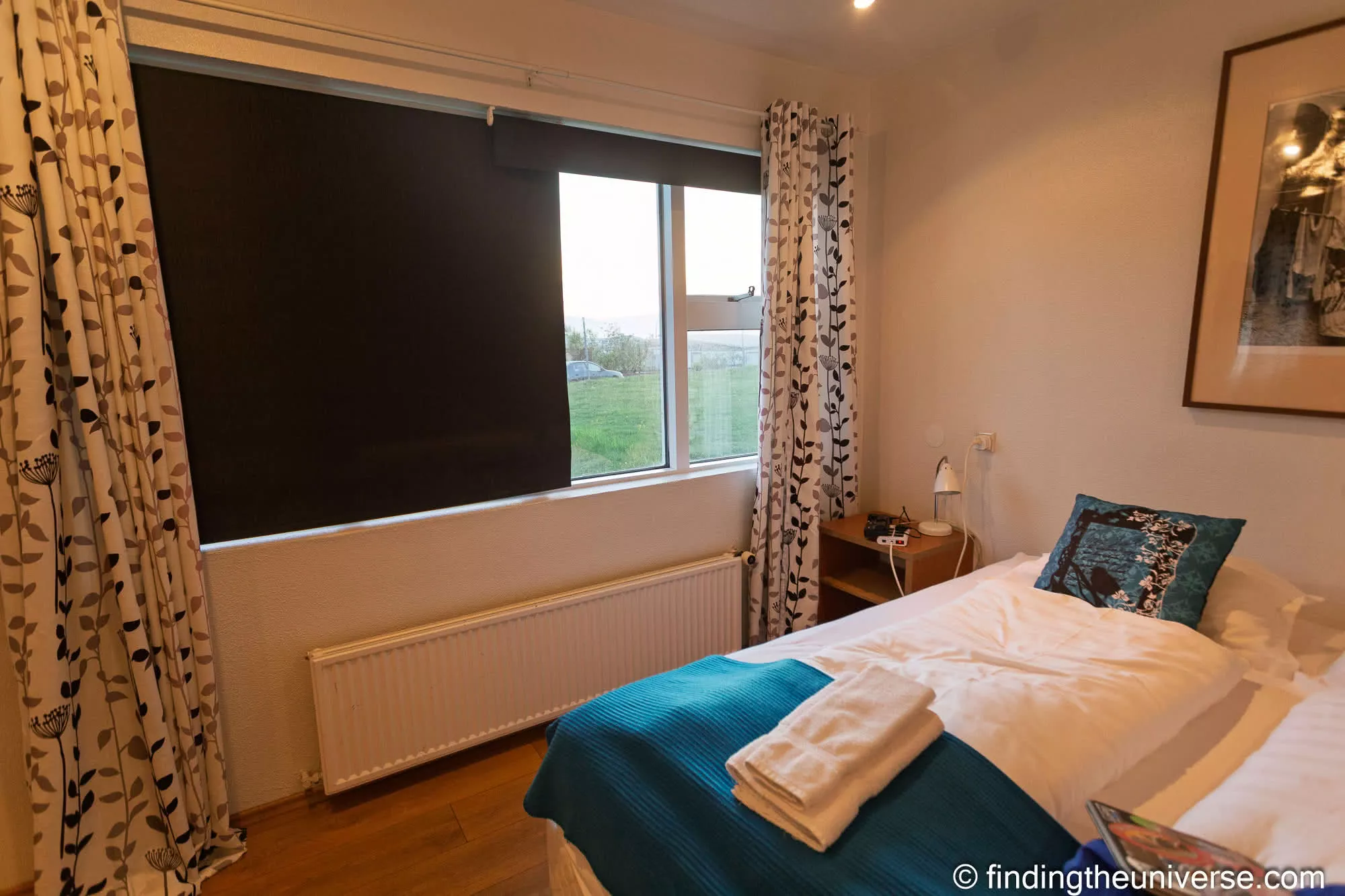 Hotel Framtid bedroom with teal bedding and a wide window