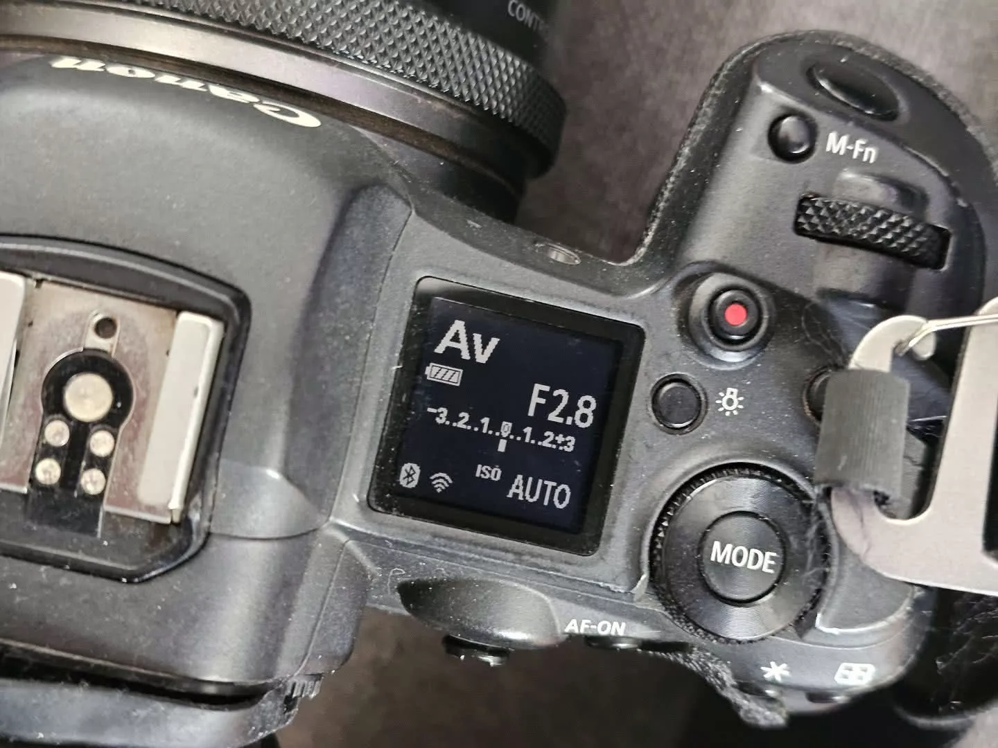 The top LCD of a Canon EOS R5 showing Av mode at f/2.8 with ISO on Auto