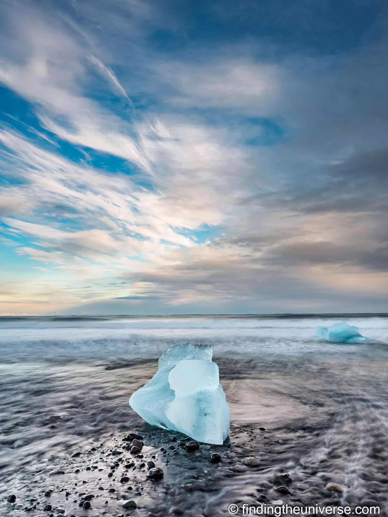 Iceberg on the black volcanic sand of Diamond Beach, Iceland, under a dramatic dawn sky