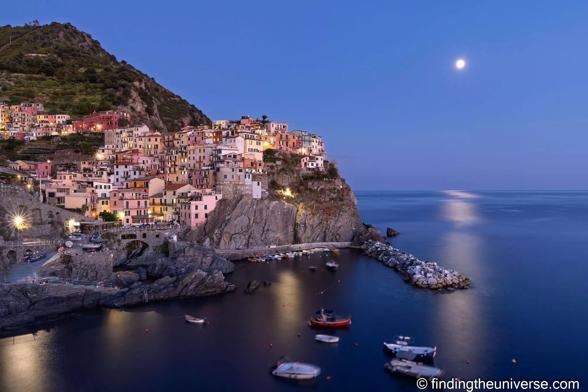 Manarola at blue hour with the moon rising over the sea