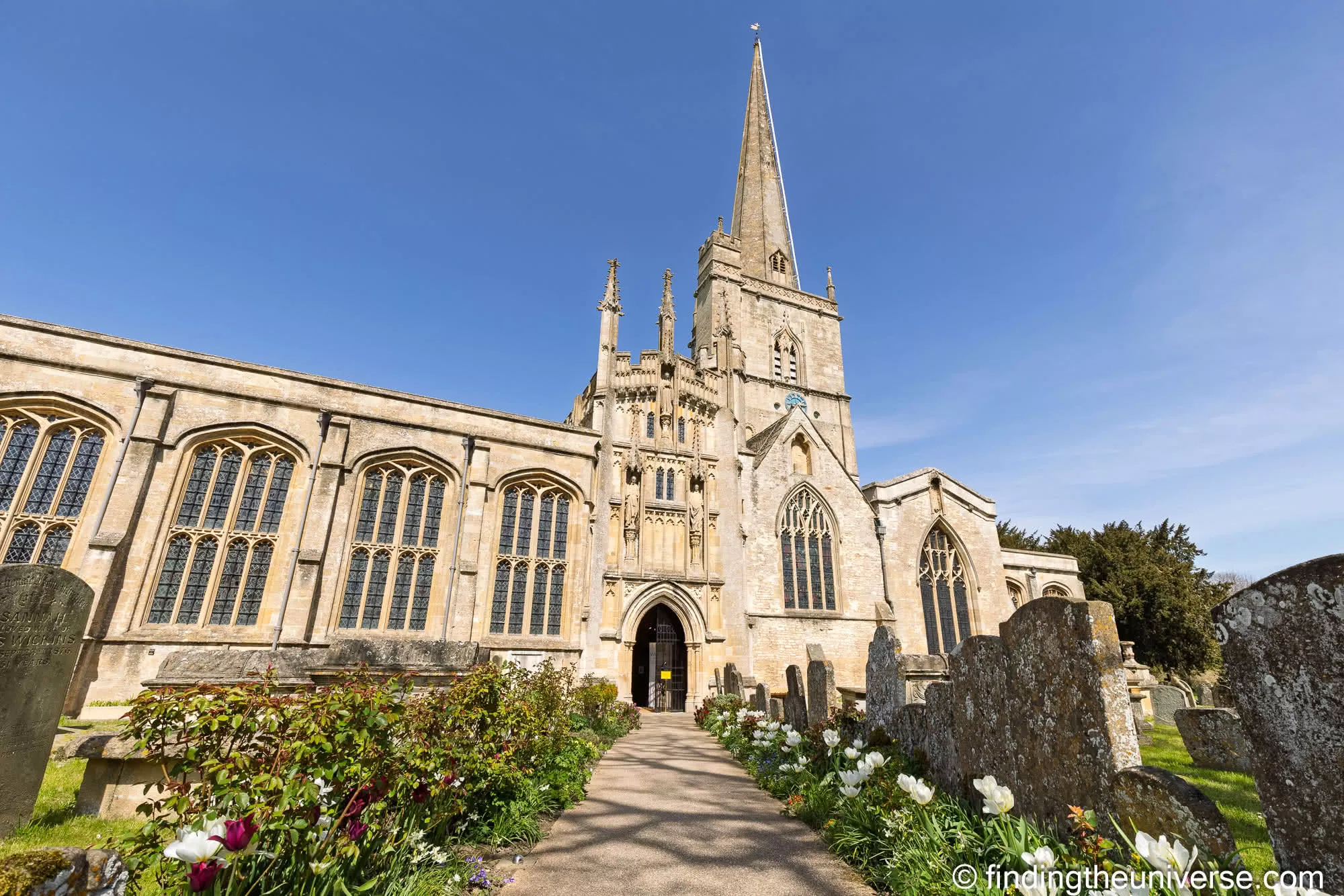 Burford church with tulips along the path