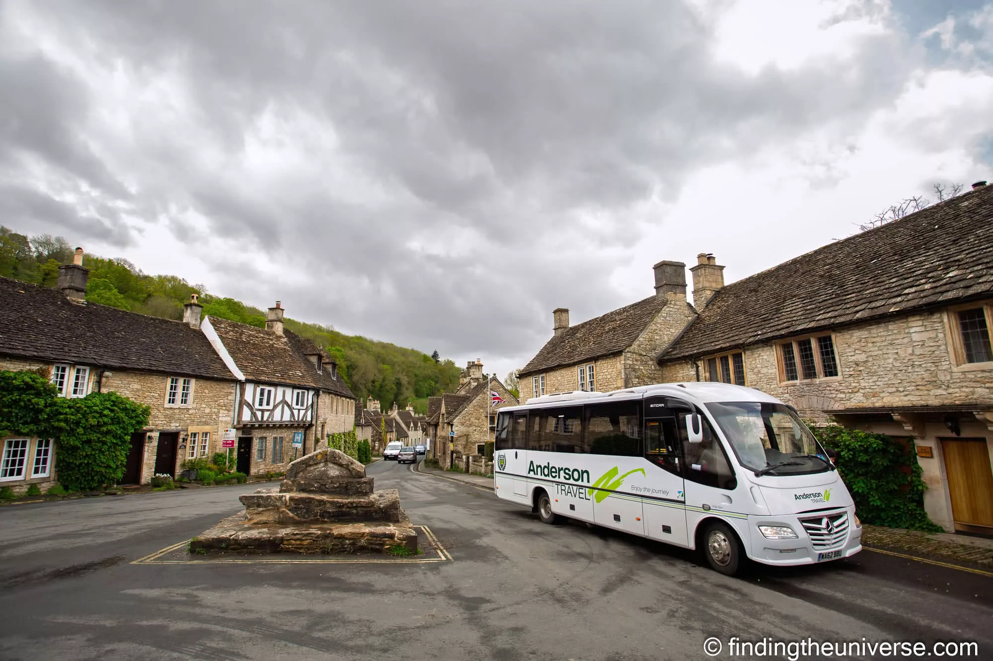 Castle Combe market cross with a tour coach