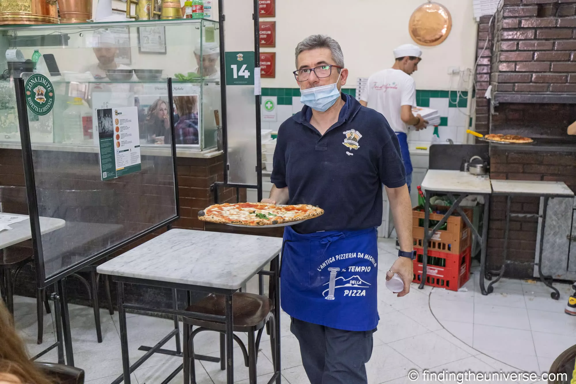 A waiter carrying a margherita at L'Antica Pizzeria da Michele, Naples