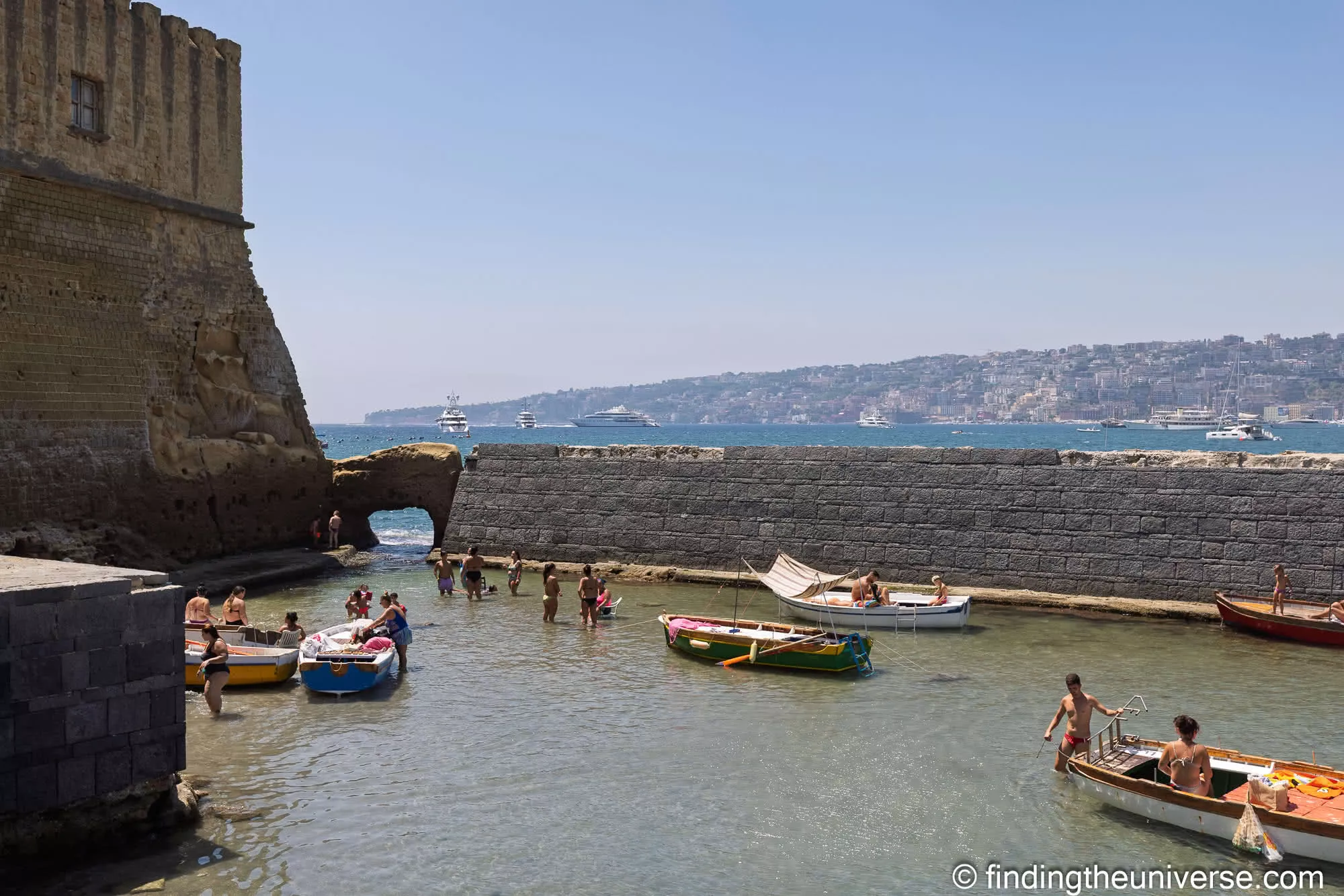 Locals swimming in the cove below Castel dell'Ovo, with the Bay of Naples beyond