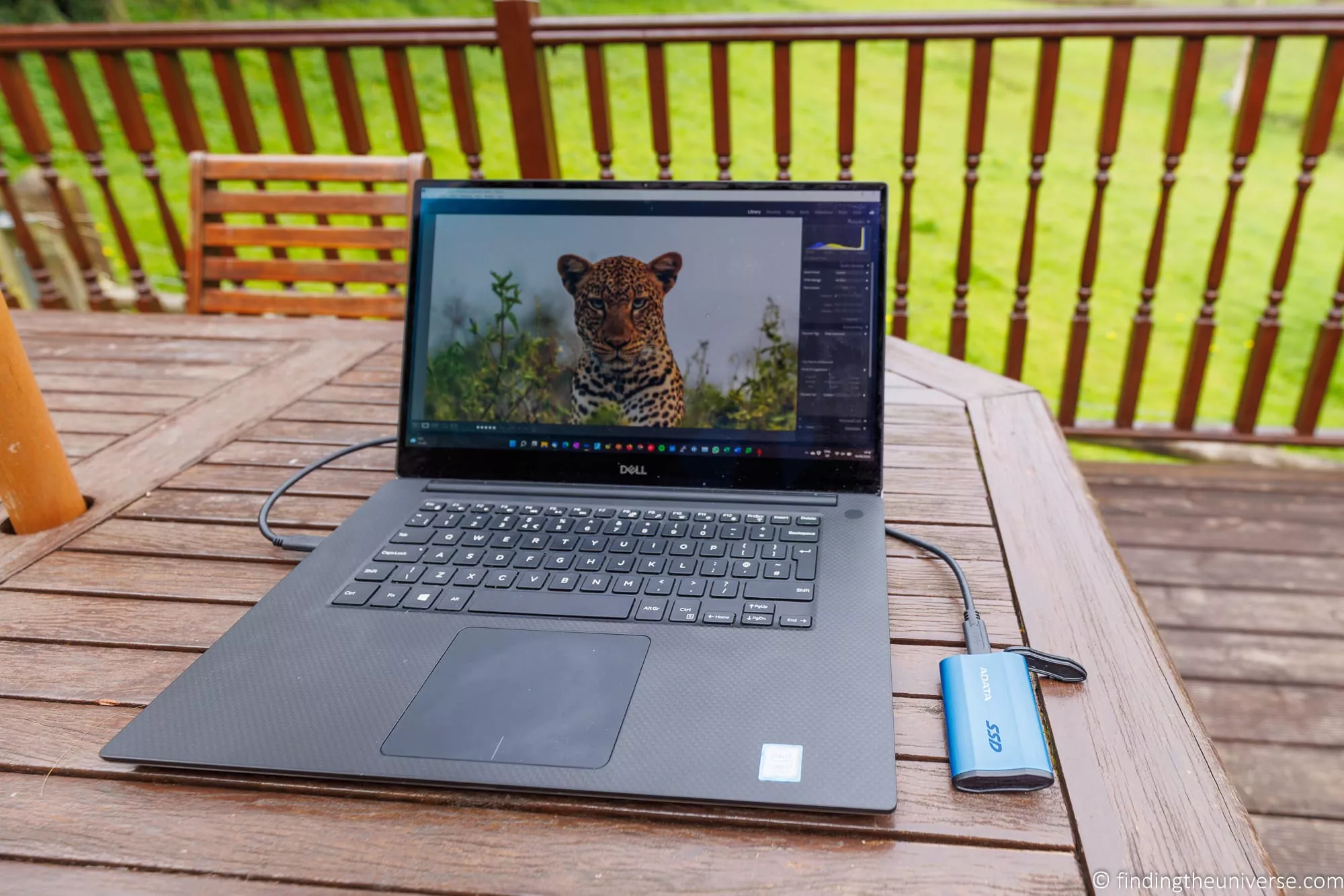 A laptop and a rugged external SSD used to back up travel photos on the road