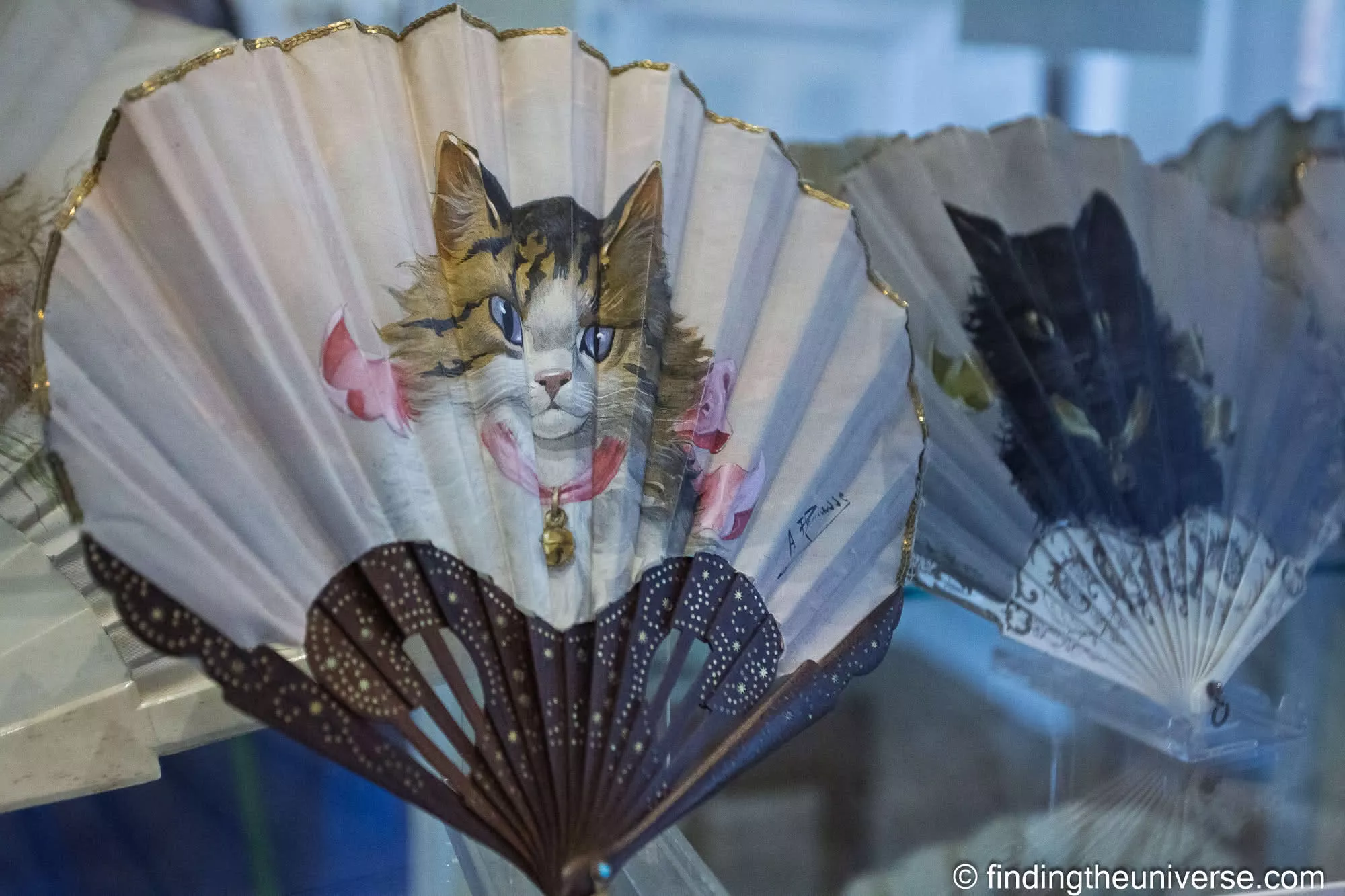 Hand-painted cat fan in a display case at the Fan Museum, Greenwich