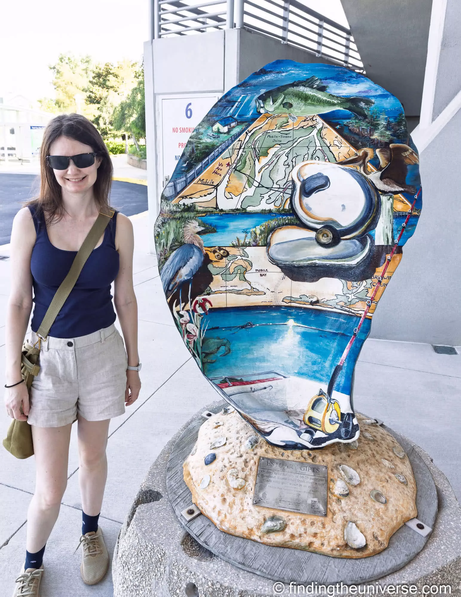 Jess beside a painted oyster sculpture, showing its scale
