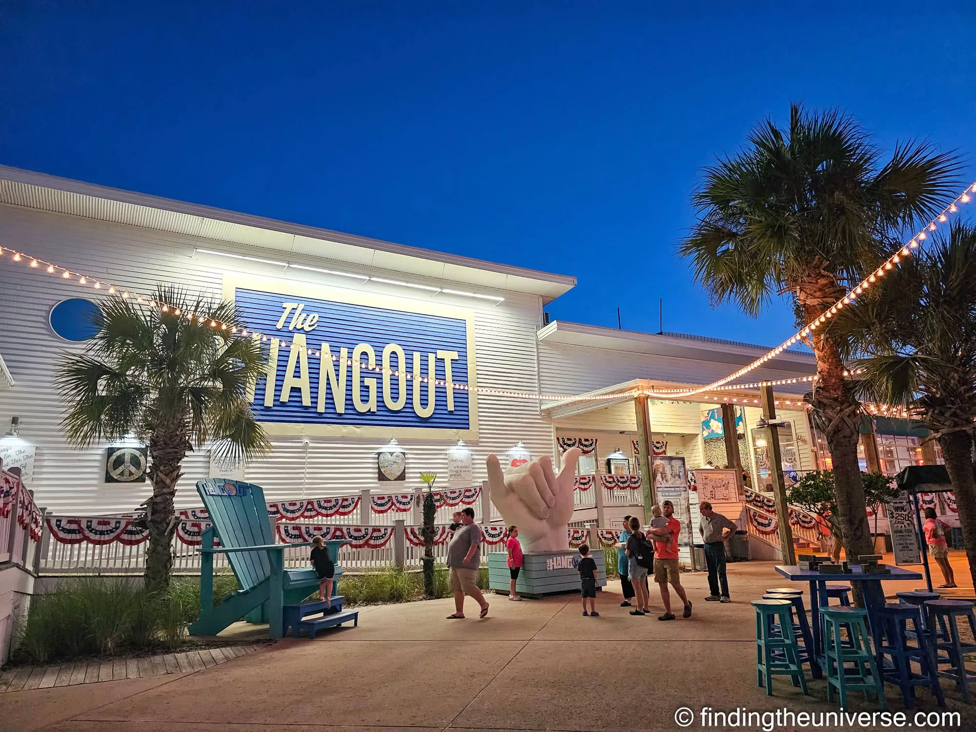 The Hangout at Gulf Place, lit up at dusk