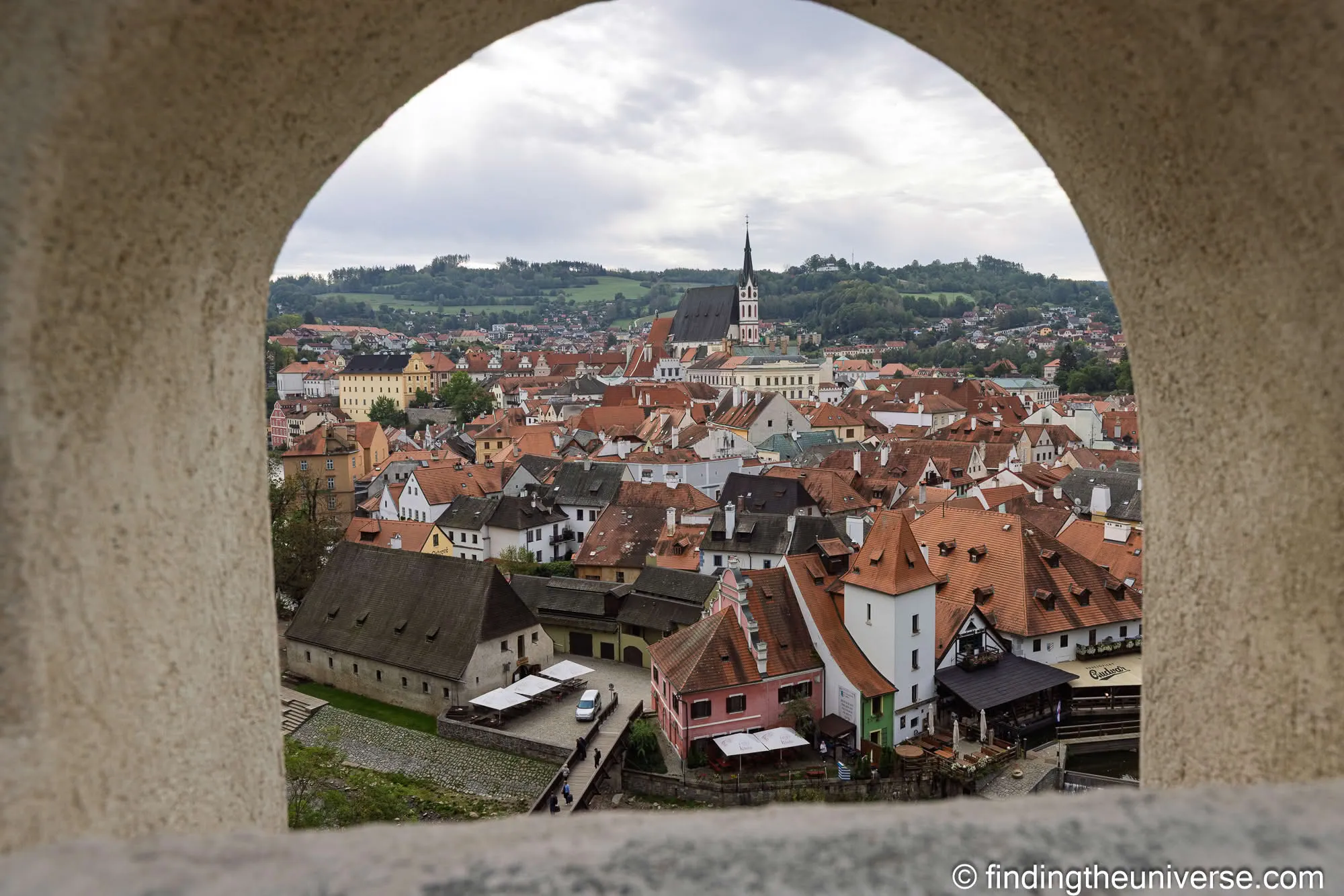 Český Krumlov rooftops through an arched window in the castle
