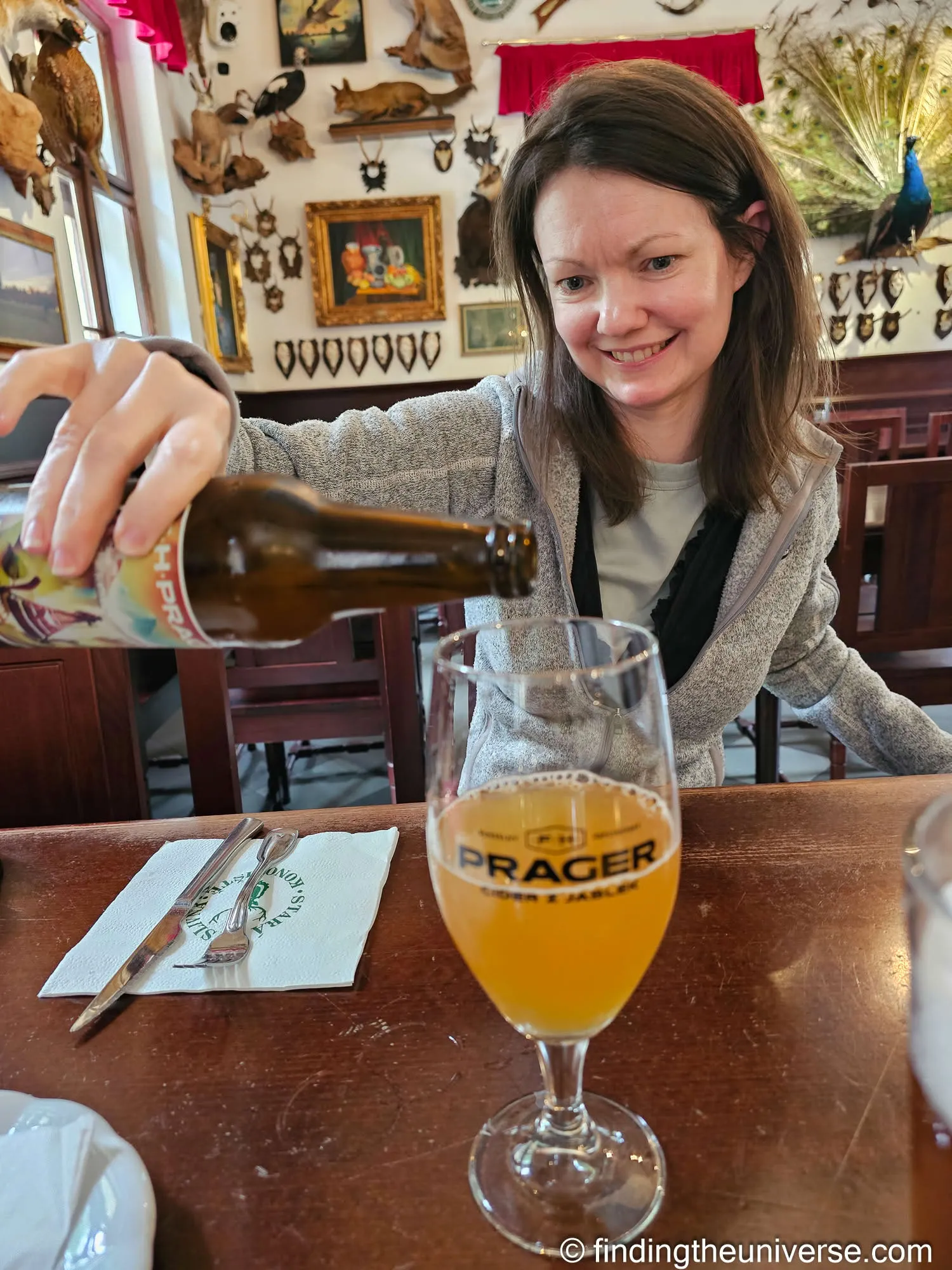 Jessica pouring a Prager cider at lunch near Konopiště