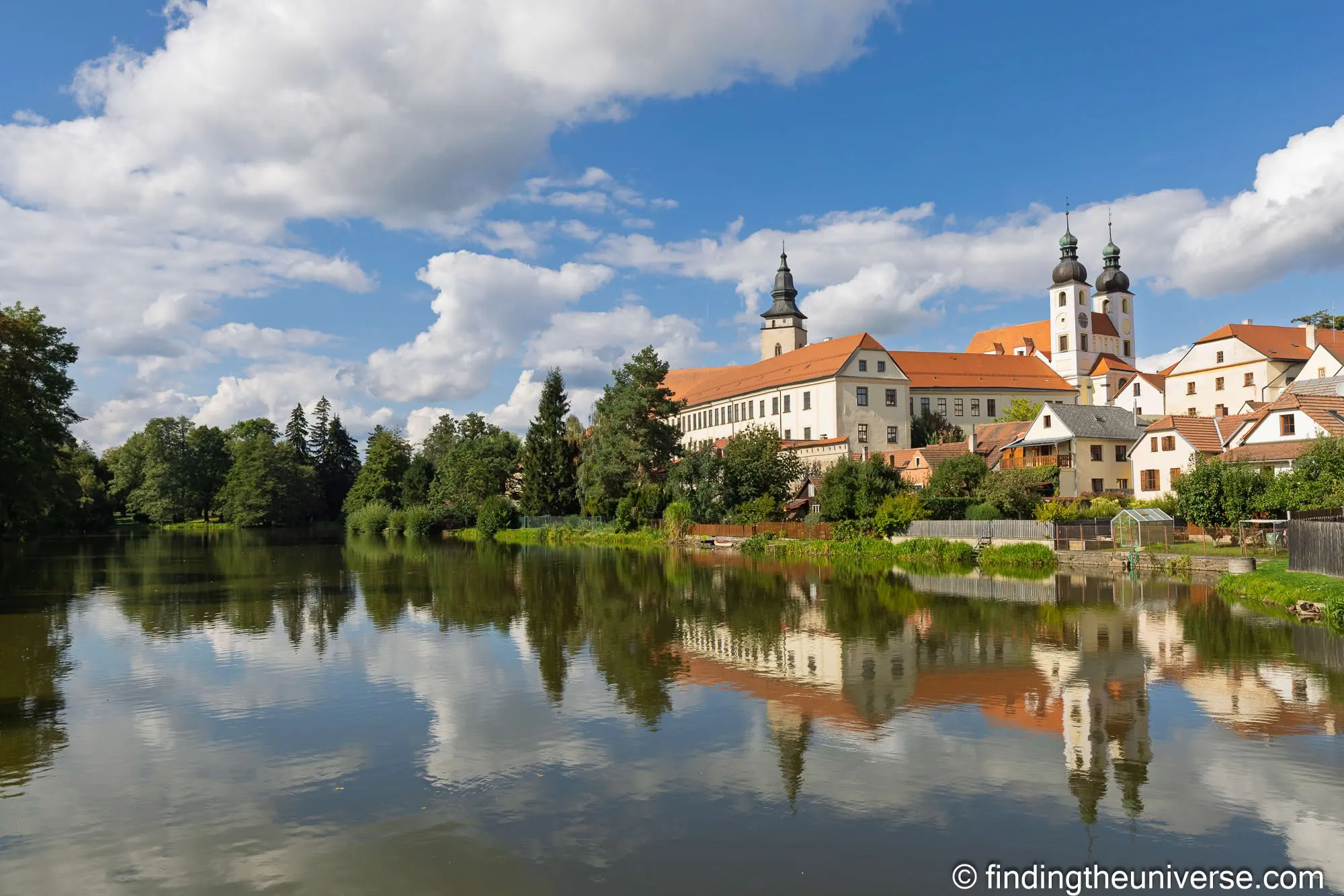 Telč chateau and church towers reflected in a pond
