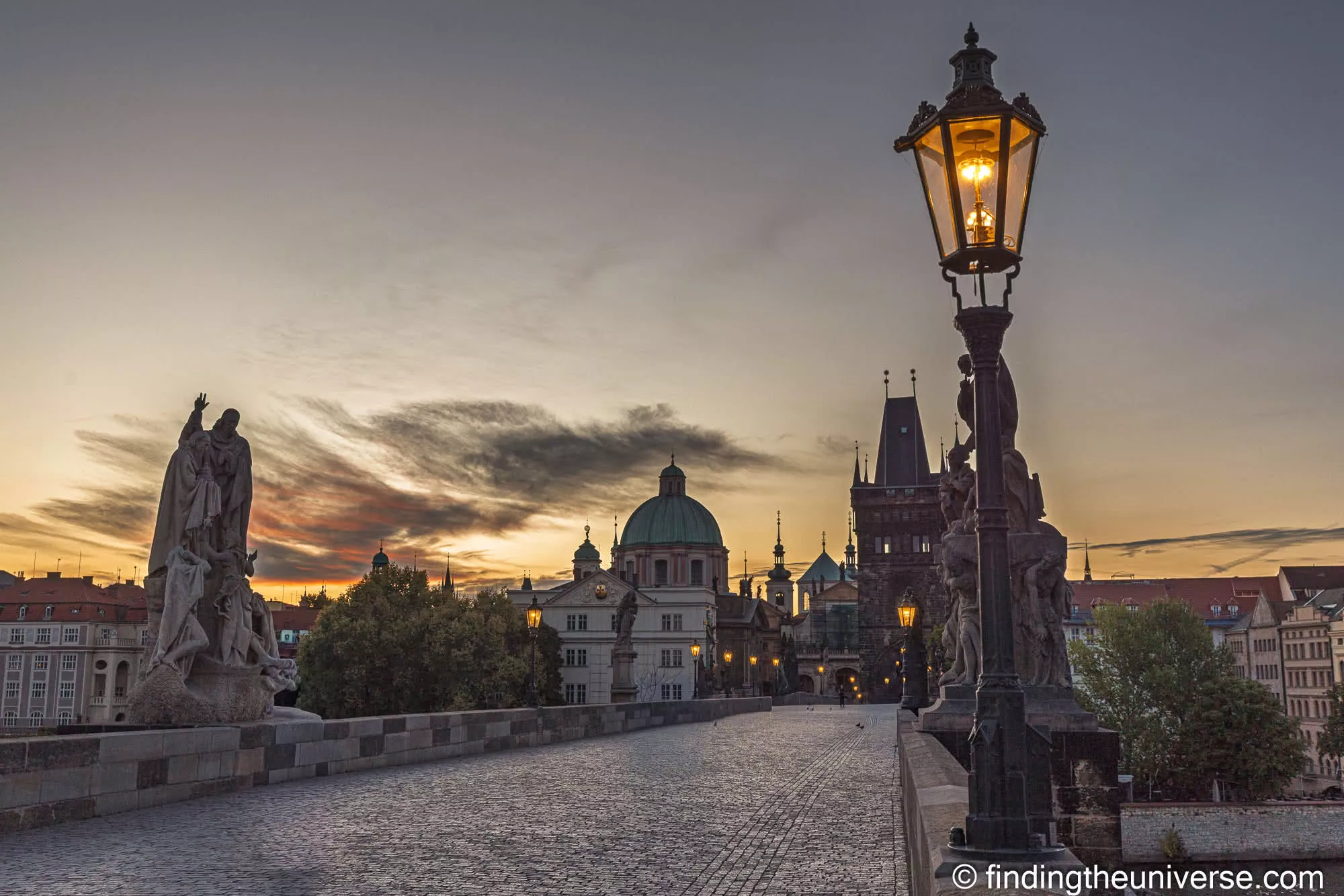 Charles Bridge statues and lamp silhouetted at dawn, Prague