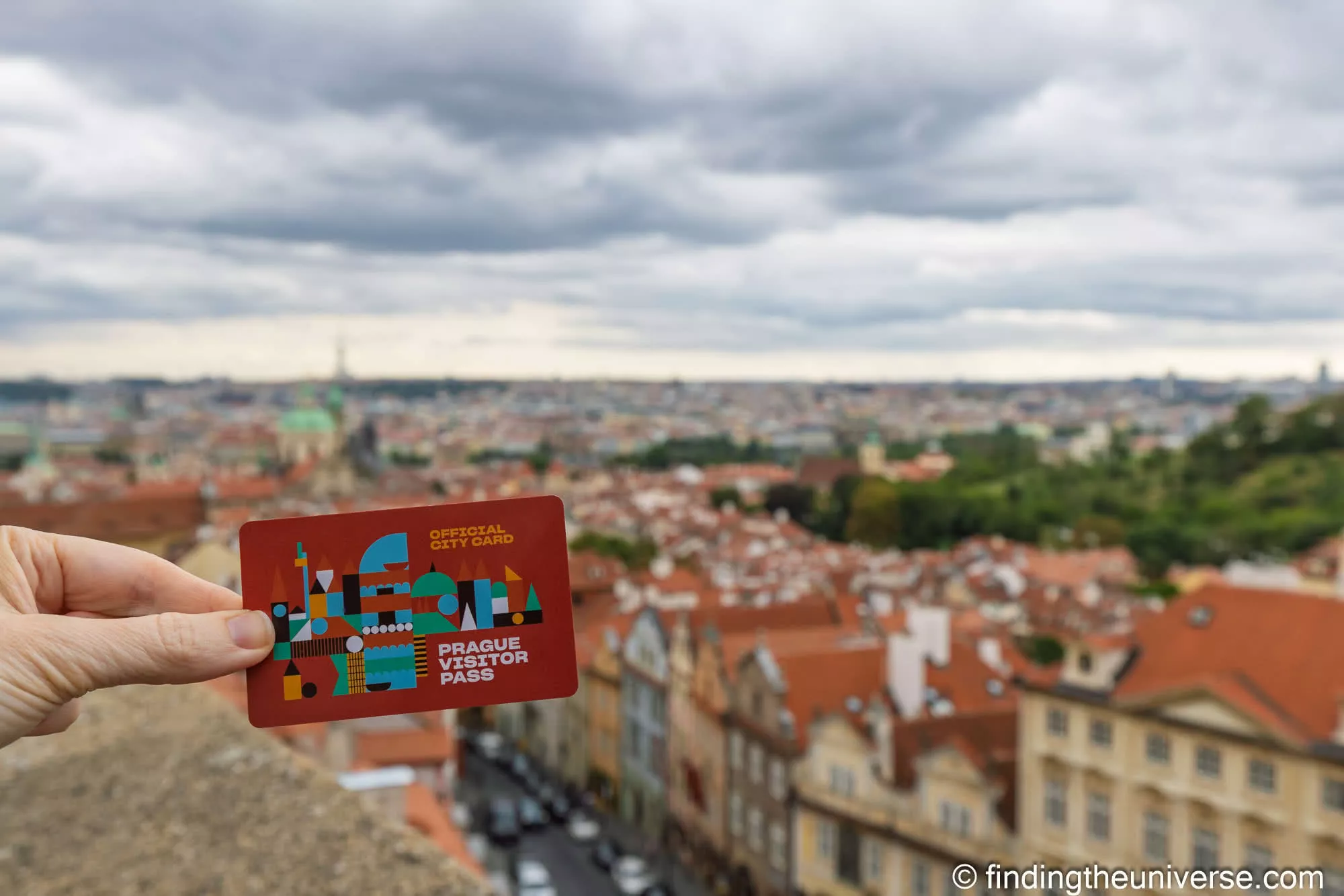 Prague Visitor Pass held up over the rooftops of Malá Strana